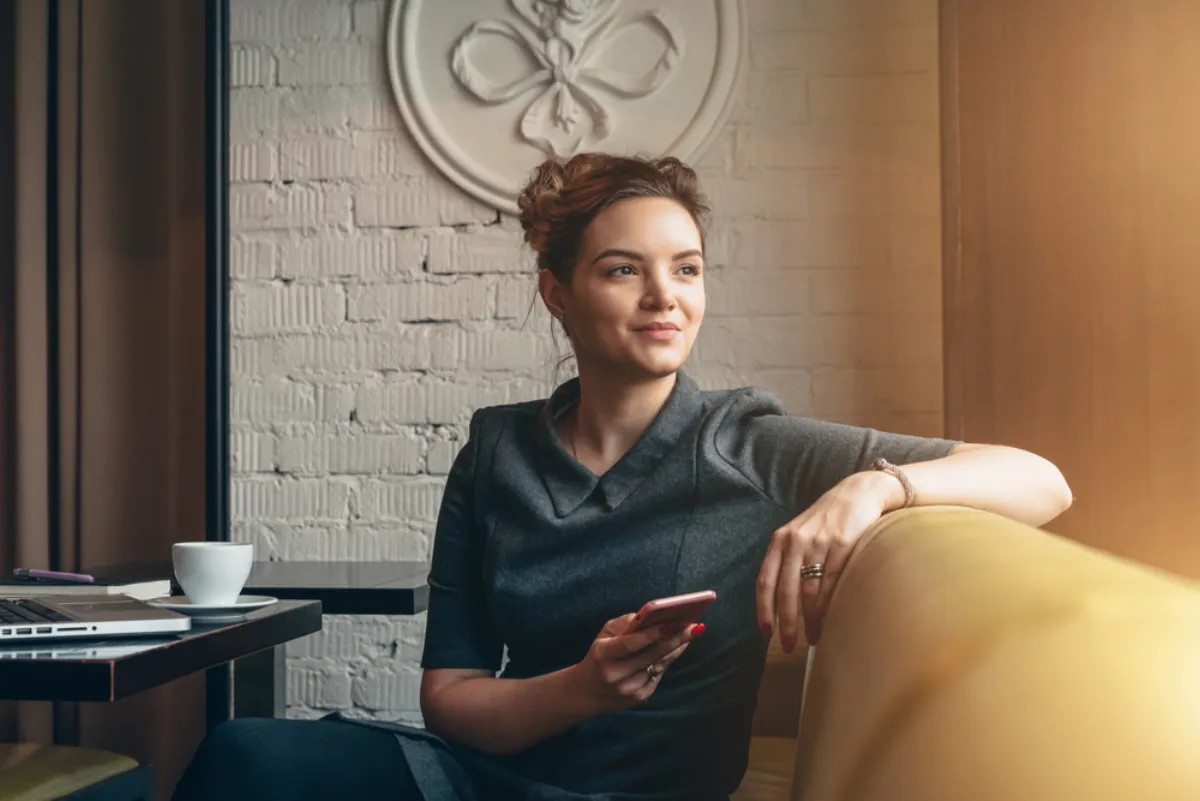 A woman sitting in a cafe window, looking out
