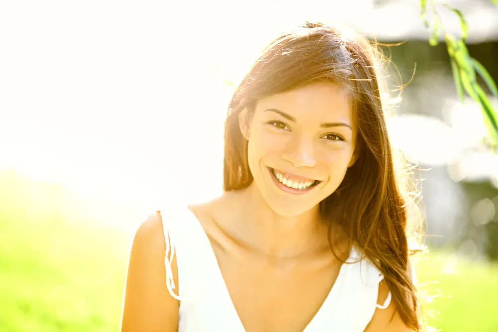 A woman smiling in warm summer sunlight