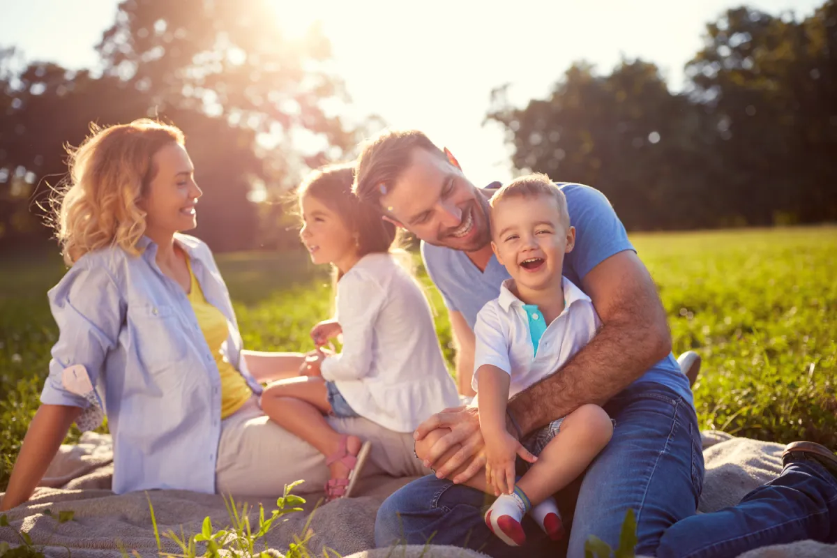 A family lying together in a sunlit field