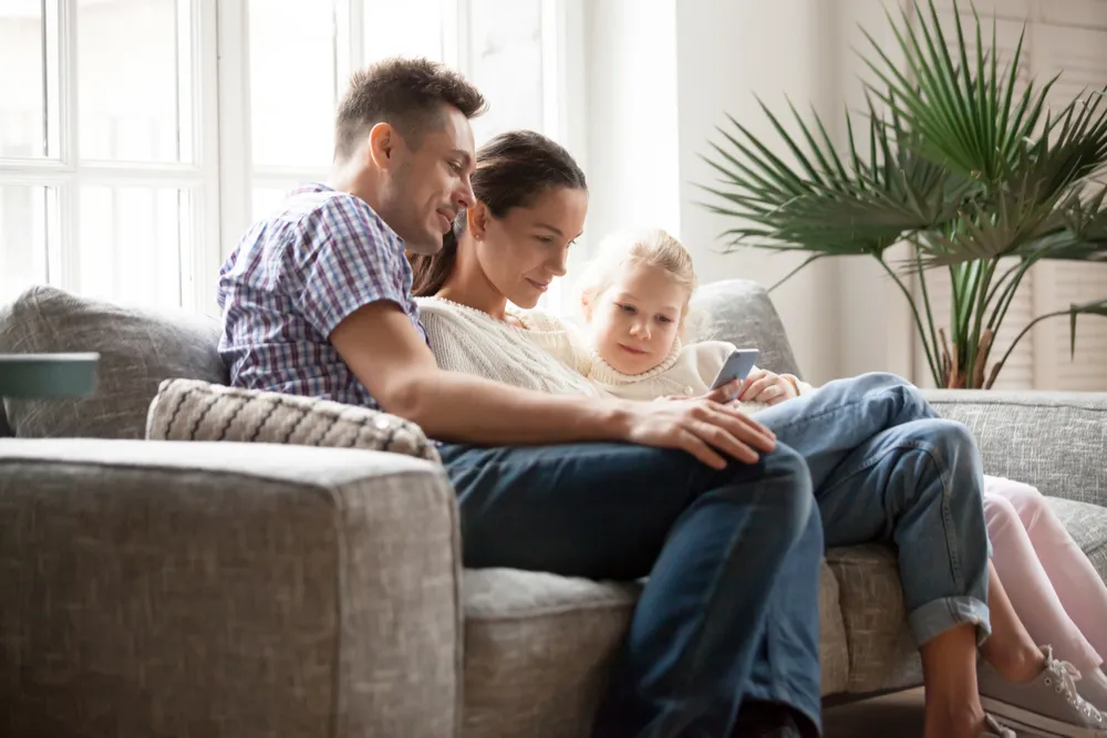 A family relaxing close together on a couch at home