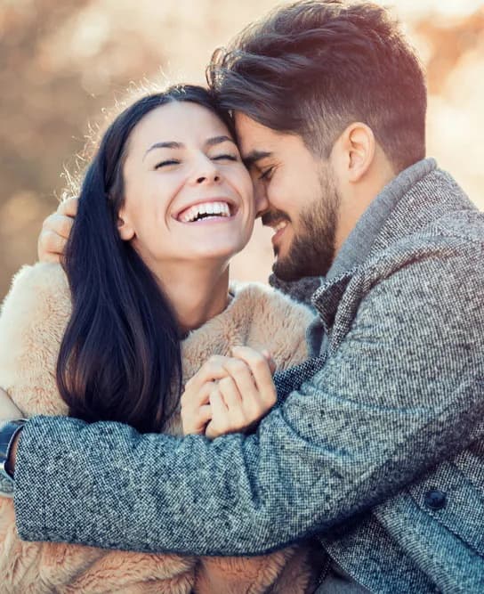 A couple embracing and laughing together outdoors