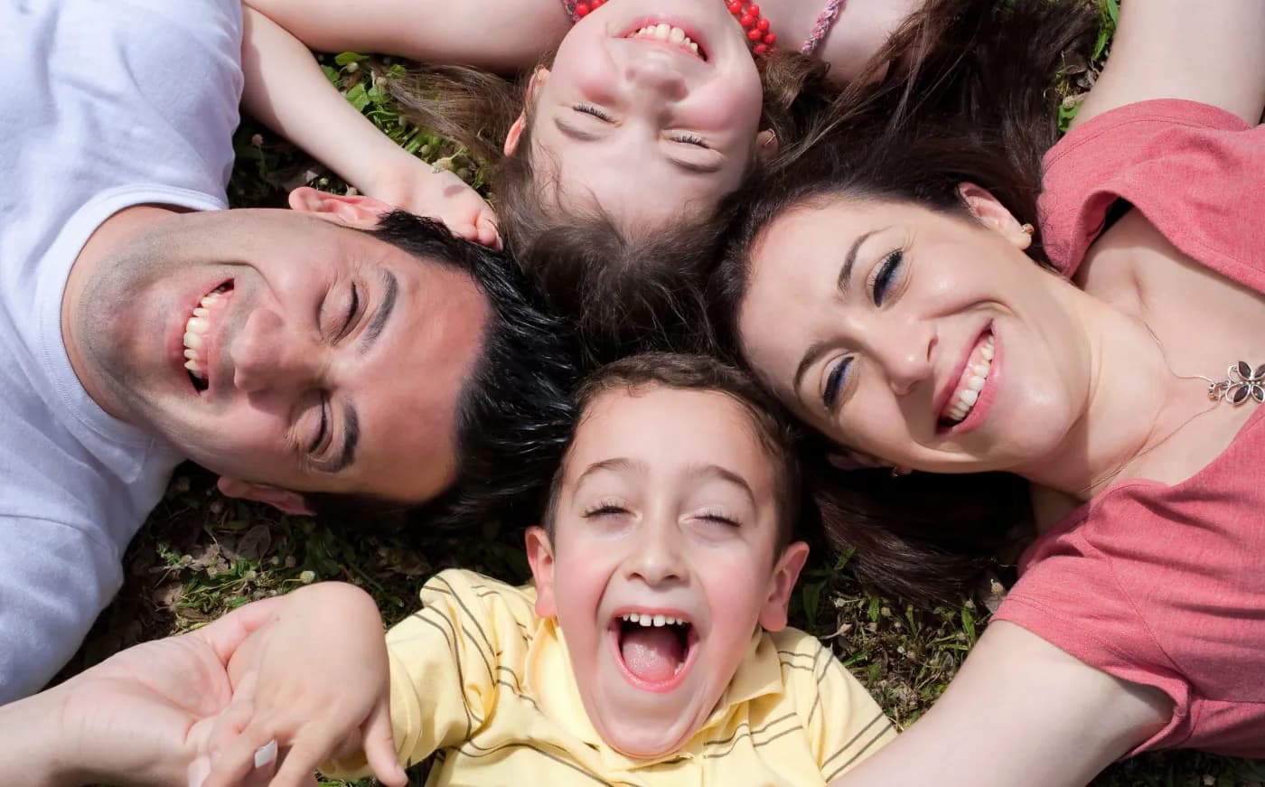 A family lying on the grass together, laughing