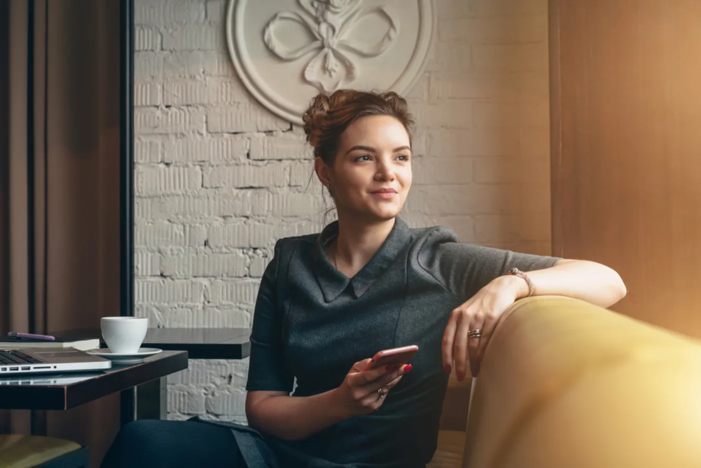 A woman sitting in a cafe, looking out of the window